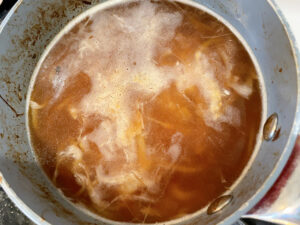オニオンスープレシピ6_玉ねぎが狐色になったら水を加えコンソメ顆粒と塩胡椒で味付けする